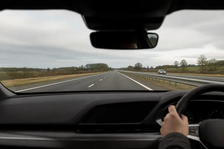 Véhicule circulant sur une route nationale sous une lumière naturelle de jour.