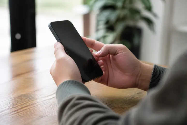 Utilisateur vérifiant les mises à jour et la compatibilité système sur son téléphone mobile