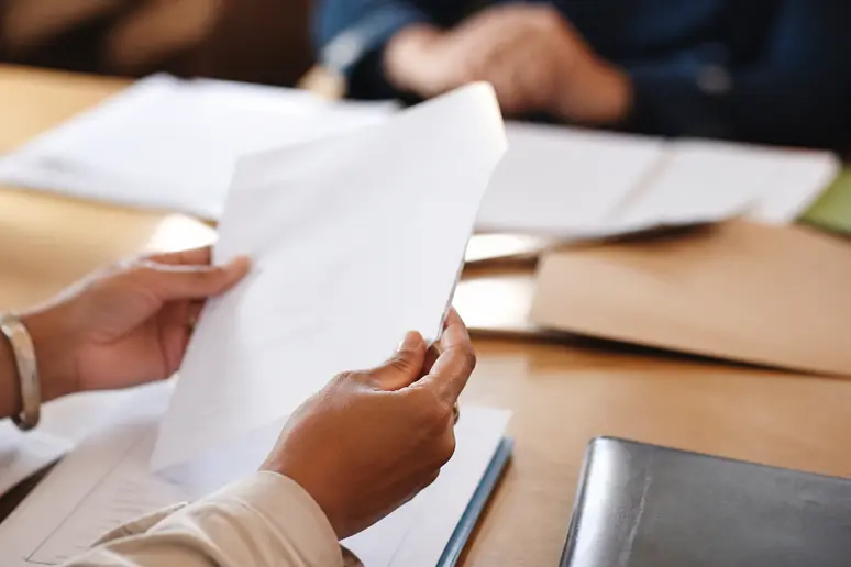 Un conducteur classe ses documents administratifs pour éviter les erreurs lors de la vérification de ses amendes en cours.