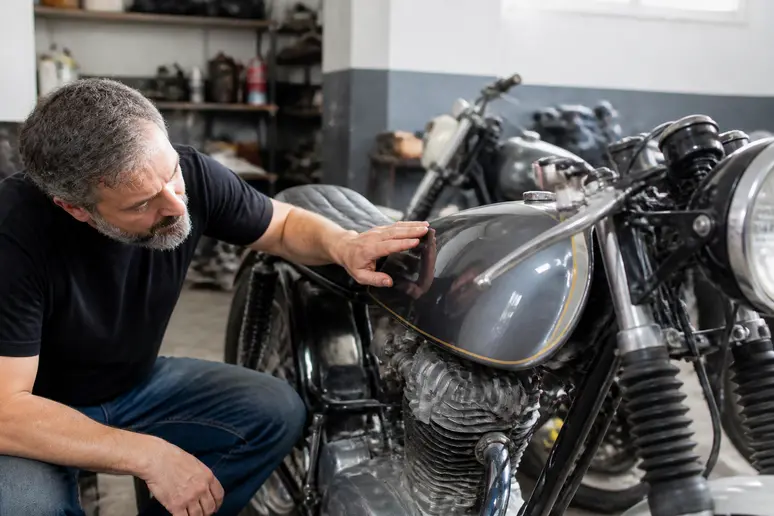 Contrôle de la peinture d'origine sur le réservoir d'une ancienne motocyclette italienne