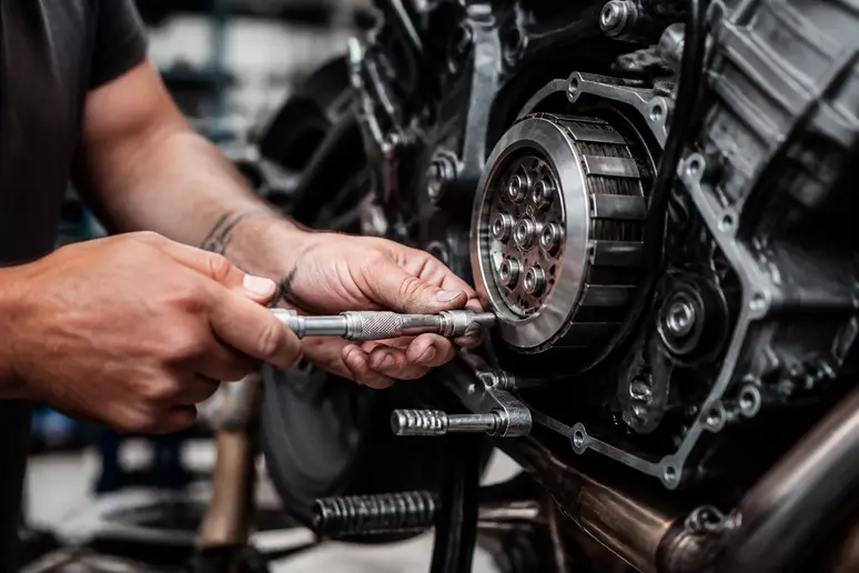 Mains d'un mécanicien travaillant sur le moteur d'une moto dans un atelier professionnel