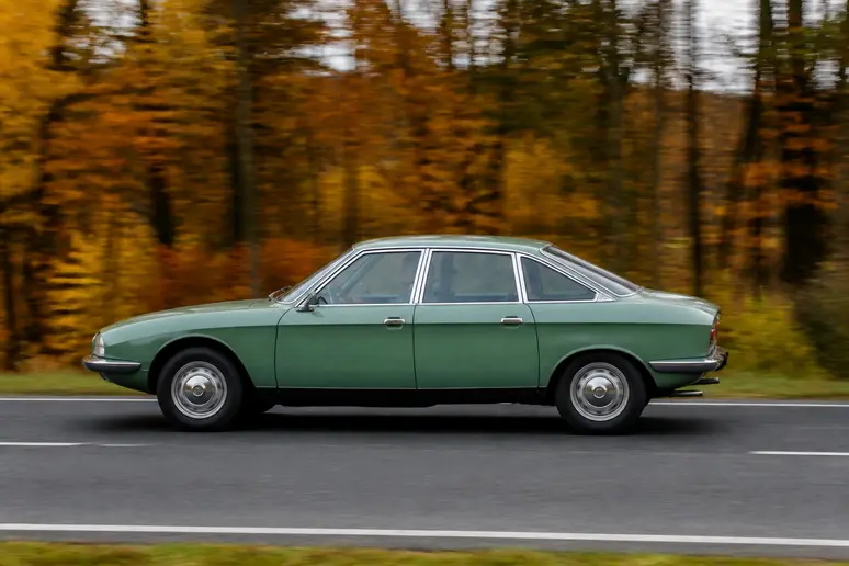 Une berline NSU Ro 80 roulant sur une route goudronnée en mettant en valeur sa ligne aérodynamique