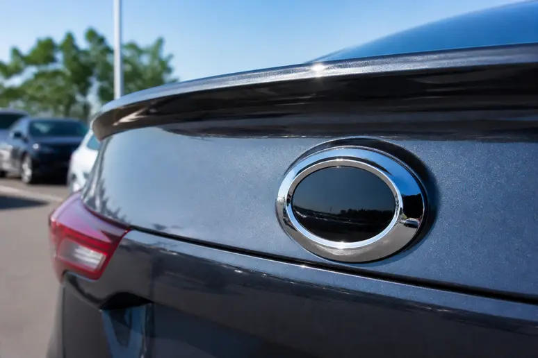 Berline Samsung stationnée sur un parking extérieur lumineux montrant son monogramme arrière