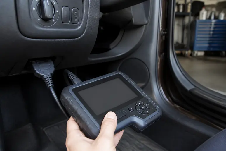 Lecteur OBD utilisé pour diagnostiquer un voyant Duster, montrant des codes d'erreur.