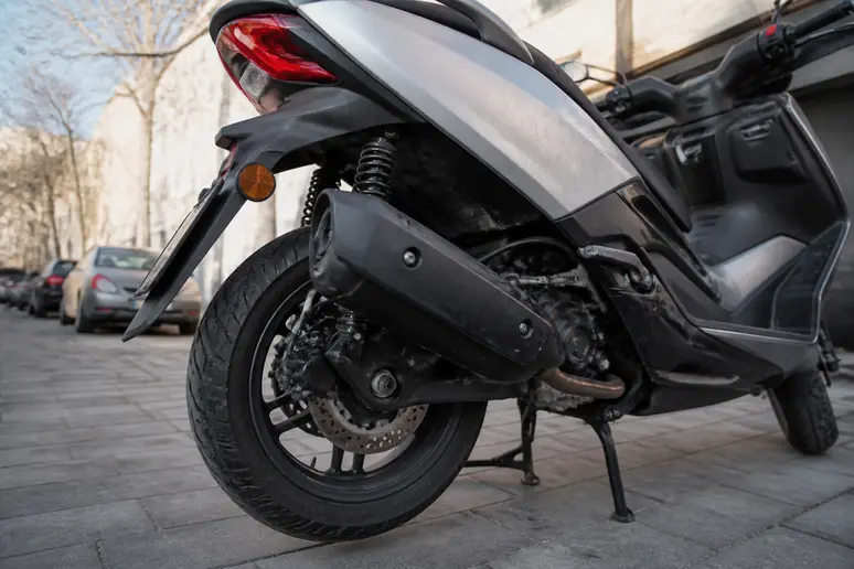 Scooter crossover Honda d occasion stationné sur une rue pavée urbaine