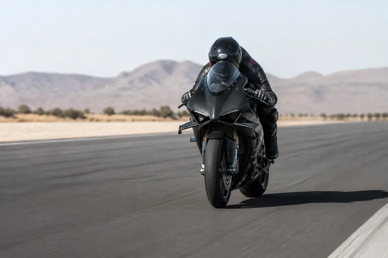 Pilote en position aérodynamique sur une hypersportive de série testée sur bitume