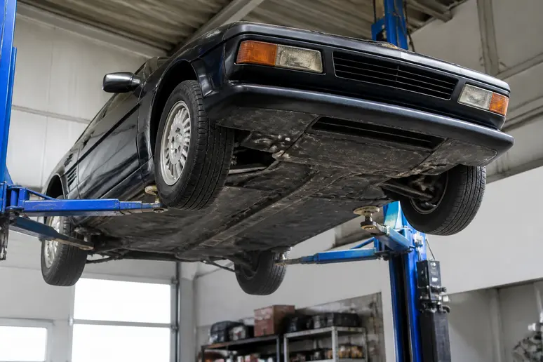 Examen du châssis et des dessous d'une Talbot-Matra Murena sur un pont de garage
