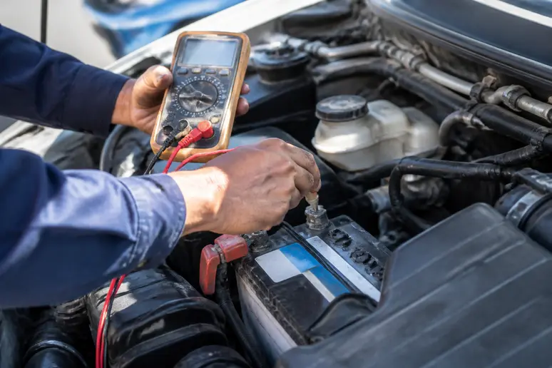 Multimètre numérique mesurant la tension de la batterie pour tester l'alternateur