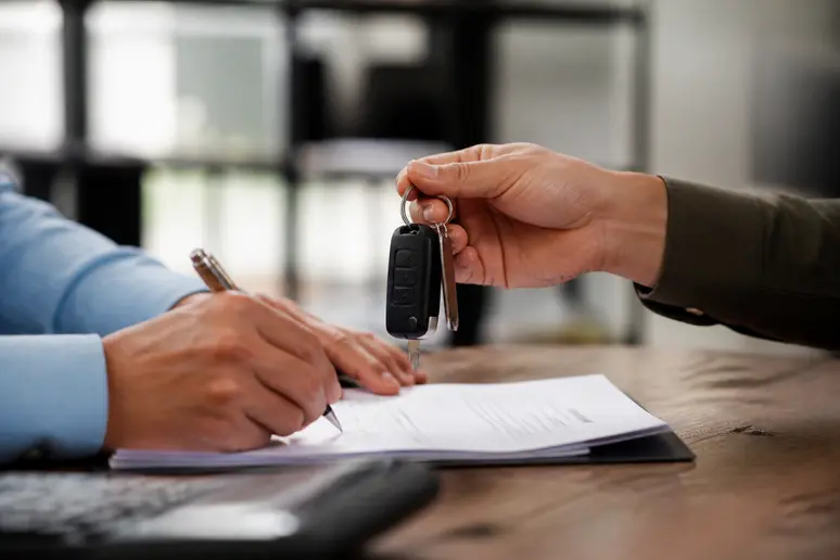 Remise des clés et signature des documents administratifs pour finaliser une reprise auto