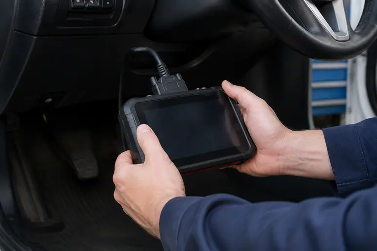 Branchement d'un boîtier de diagnostic OBD2 sous le tableau de bord pour résoudre le voyant d'injection