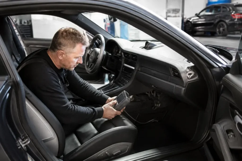 Porsche occasion Allemagne : le piège du compteur trafiqué Diagnostic professionnel dans un atelier pour verifier une Porsche occasion Allemagne